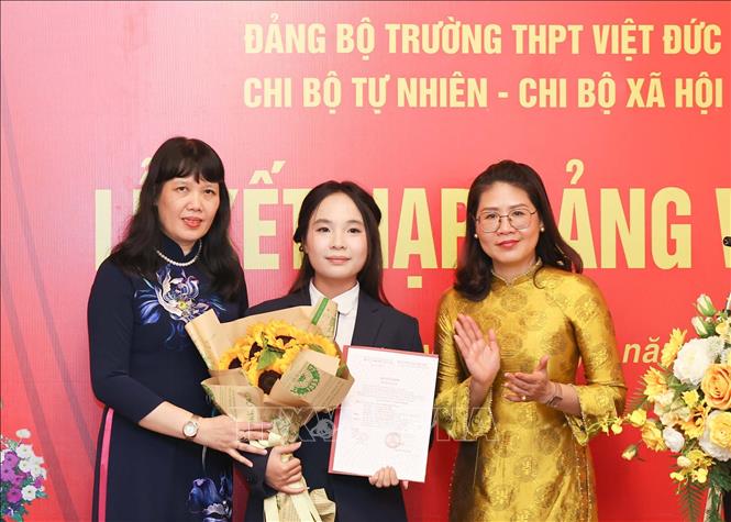 Phó Bí thư thường trực Đảng ủy phường Cửa Nam Phạm Thị Thu Thủy cùng Bí thư Đảng ủy, Hiệu trưởng Trường THPT Việt Đức Nguyễn Bội Quỳnh trao Quyết định kết nạp Đảng cho học sinh. Ảnh: Thanh Tùng – TTXVN