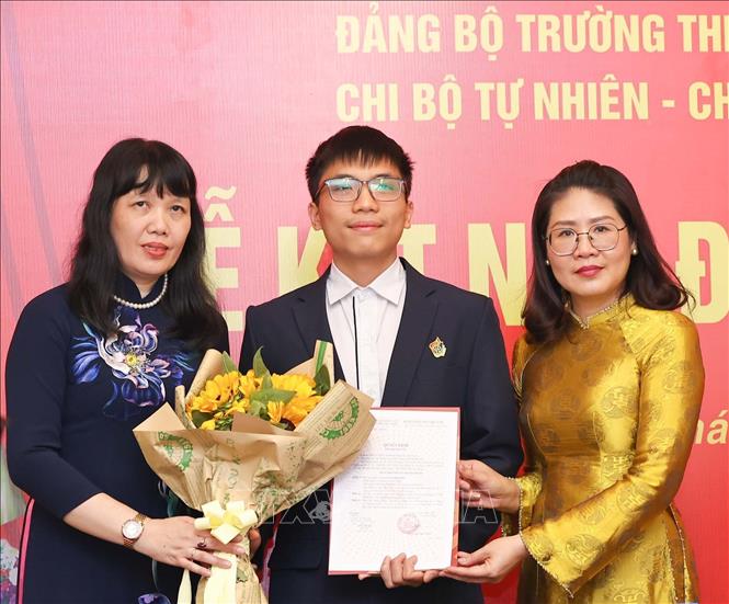 Phó Bí thư thường trực Đảng ủy phường Cửa Nam Phạm Thị Thu Thủy cùng Bí thư Đảng ủy, Hiệu trưởng Trường THPT Việt Đức Nguyễn Bội Quỳnh trao Quyết định kết nạp Đảng cho học sinh. Ảnh: Thanh Tùng – TTXVN