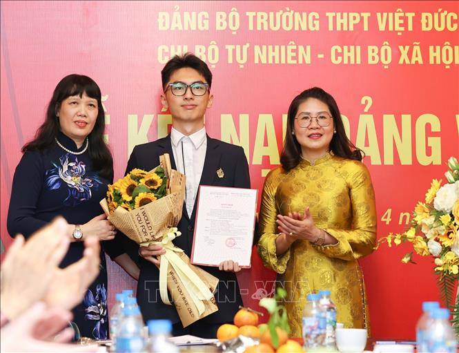 Phó Bí thư thường trực Đảng ủy phường Cửa Nam Phạm Thị Thu Thủy cùng Bí thư Đảng ủy, Hiệu trưởng Trường THPT Việt Đức Nguyễn Bội Quỳnh trao Quyết định kết nạp Đảng cho học sinh. Ảnh: Thanh Tùng – TTXVN