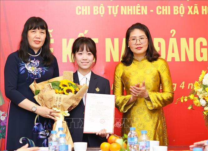 Phó Bí thư thường trực Đảng ủy phường Cửa Nam Phạm Thị Thu Thủy cùng Bí thư Đảng ủy, Hiệu trưởng Trường THPT Việt Đức Nguyễn Bội Quỳnh trao Quyết định kết nạp Đảng cho học sinh. Ảnh: Thanh Tùng – TTXVN