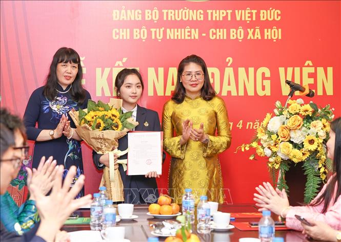 Phó Bí thư thường trực Đảng ủy phường Cửa Nam Phạm Thị Thu Thủy cùng Bí thư Đảng ủy, Hiệu trưởng Trường THPT Việt Đức Nguyễn Bội Quỳnh trao Quyết định kết nạp Đảng cho học sinh. Ảnh: Thanh Tùng – TTXVN