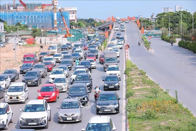 Lưu lượng người và phương tiện di chuyển về hướng đường Cổ Linh tăng đột biến, xuất hiện hiện tượng ùn ứ cục bộ. Ảnh: Hoàng Hiếu - TTXVN