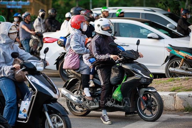 Người dân di chuyển bằng xe máy mang theo hành lý, đồ đạc để về quê, tận dụng phương tiện cá nhân trong dịp nghỉ lễ. Ảnh: Phạm Tuấn Anh - TTXVN