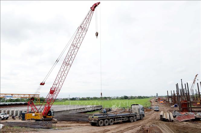 Nhiều phương tiện máy móc hiện đại trong thi công cầu được huy động nhằm hoàn thành tiến độ vào tháng 6/2027. Ảnh: Mạnh Khánh - TTXVN