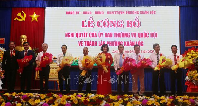 Tặng hoa, quà cho các đồng chí nguyên lãnh đạo phường Xuân Lộc, tỉnh Đồng Nai. Ảnh: Lê Xuân - TTXVN