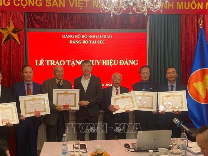 Đồng chí Dương Hoài Nam, Đại sứ Việt Nam tại Cộng hòa Séc trao huy hiệu 30 và 55 năm tuổi đảng cho các đảng viên. Ảnh: Việt Thắng - P/v TTXVN tại CH Séc