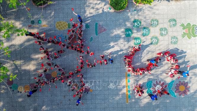 Cô và trò Trường Mẫu giáo Vàng Anh (xã Châu Thành) xếp hình chữ S bản đồ Việt Nam và ngôi sao đầy ý nghĩa. Ảnh: Giang Phương - TTXVN 