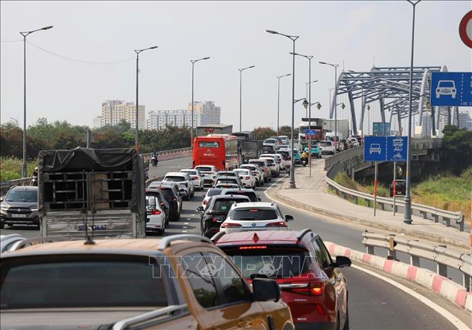 Các phương tiện nối đuôi lên cầu Phú Hữu, phường Long Trường, sáng 30/4. Ảnh: Hồng Đạt - TTXVN