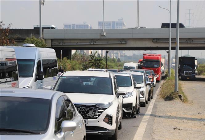 Các phương tiện di chuyển chậm trong điều kiện thời tiết nắng nóng, oi bức trên đường Võ Chí Công, phường Long Trường, sáng 30/4. Ảnh: Hồng Đạt - TTXVN