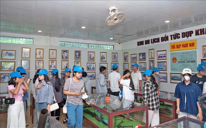 Du khách tham quan các hiện vật gắn với cuộc chiến đấu 128 ngày đêm huyền thoại tại đồi Tức Dụp, xã Ô Lâm, tỉnh An Giang trong kháng chiến chống Mỹ, cứu nước. Ảnh: Công Mạo - TTXVN