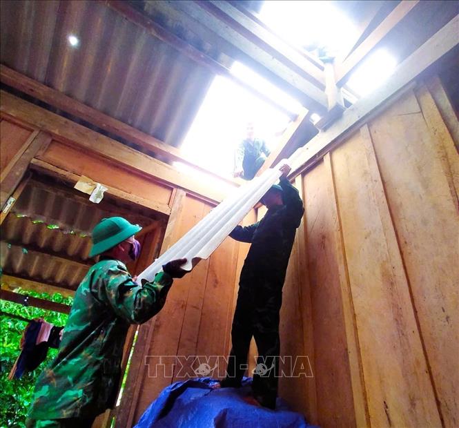 Cán bộ, chiến sĩ Đồn Biên phòng Tam Hợp (Bộ đội Biên phòng Nghệ An) chuẩn bị tấm lợp giúp dân khắc phục nhà dân bị tốc mái. Ảnh: TTXVN phát
