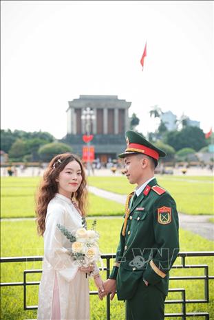 Cặp đôi chụp ảnh lưu niệm tại khu vực Quảng trường Ba Đình. Ảnh: Phạm Tuấn Anh - TTXVN