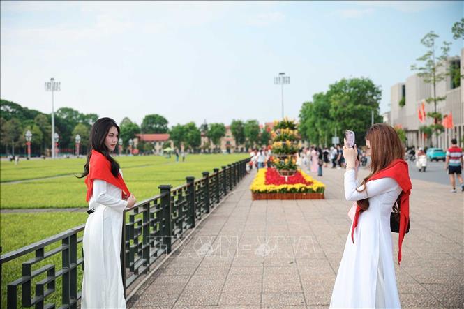 Nhiều bạn trẻ lựa chọn trang phục áo dài truyền thống khi tham quan và chụp ảnh tại khu vực Quảng trường Ba Đình, Lăng Chủ tịch Hồ Chí Minh. Ảnh: Phạm Tuấn Anh - TTXVN