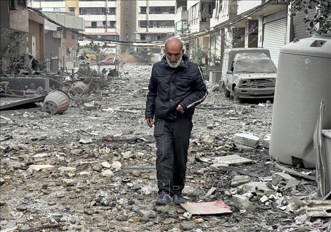 Người dân di chuyển giữa đống đổ nát của những toà nhà sau các vụ oanh tạc của Israel xuống ngoại ô thủ đô Beirut, Liban ngày 7/3/2026. Ảnh: THX/TTXVN
