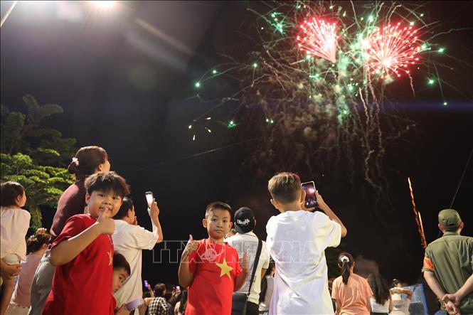 Các em nhỏ phường Lộc Ninh thích thú xem bắn pháo hoa. Ảnh: TTXVN