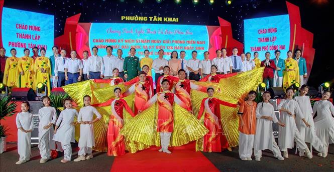 Các đại biểu và diễn viên chụp ảnh lưu niệm tại chương trình văn nghệ và bắn pháo hoa tại phường Tân Khai. Ảnh: TTXVN