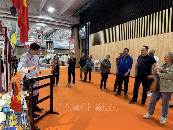 Khách tham quan thưởng thức tiết mục trình diễn đàn bầu tại Hội chợ quốc tế Paris. Ảnh: Hữu Chiến - P/v TTXVN tại Pháp 