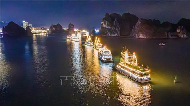 Song song với các hoạt động trên đường bao biển Trần Quốc Nghiễn, đoàn tàu du lịch với gần 100 chiếc trình diễn theo đội hình trên vịnh, tạo nên sự kết nối không gian nghệ thuật độc đáo giữa đất liền và mặt biển. Ảnh: TTXVN phát 