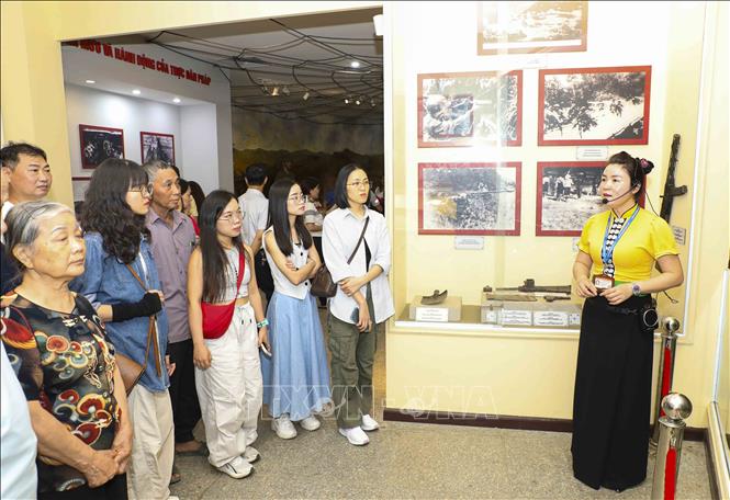 Thuyết minh viên hướng dẫn du khách tham quan tại Nhà trưng bày Bảo tàng Chiến thắng Điện Biên Phủ. Ảnh: Xuân Tư - TTXVN
