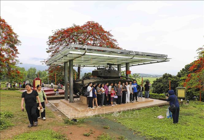Du khách tham quan, chụp ảnh check in tại Di tích Đồi A1. Ảnh: Xuân Tư - TTXVN