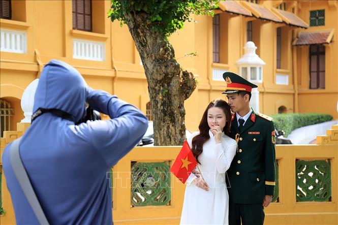 Một đôi bạn trẻ chụp ảnh lưu giữ những khắc đẹp trong những ngày tháng lịch sử của dân tộc. Ảnh: Tuấn Anh - TTXVN