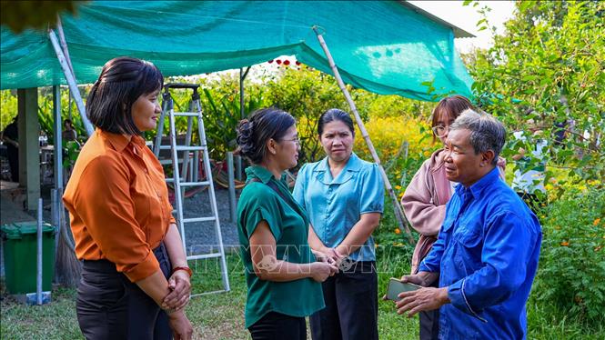 Ông Nguyễn Thanh Vũ (bìa phải), chủ vườn dâu tằm “Ba Phong”, chia sẻ kỹ thuật canh tác hữu cơ với khách tham quan. Ảnh: Minh Phú – TTXVN