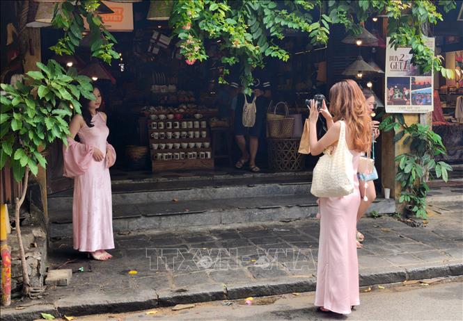 Du khách tranh thủ lưu giữ từng góc ảnh đẹp trên phố cổ. Ảnh: Quốc Dũng - TTXVN