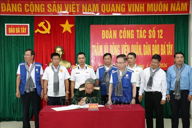 Trung tướng Phạm Văn Dỹ, nguyên Chính ủy Quân khu 7 viết sổ lưu niệm tại đảo Đá Tây A. Ảnh: Tiến Lực - TTXVN