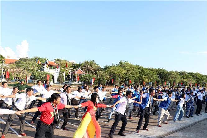 Các đại biểu thực hiện màn đồng diễn tại khu vực sân bay, trước cột mốc đảo Trường Sa. Ảnh: Tiến Lực - TTXVN