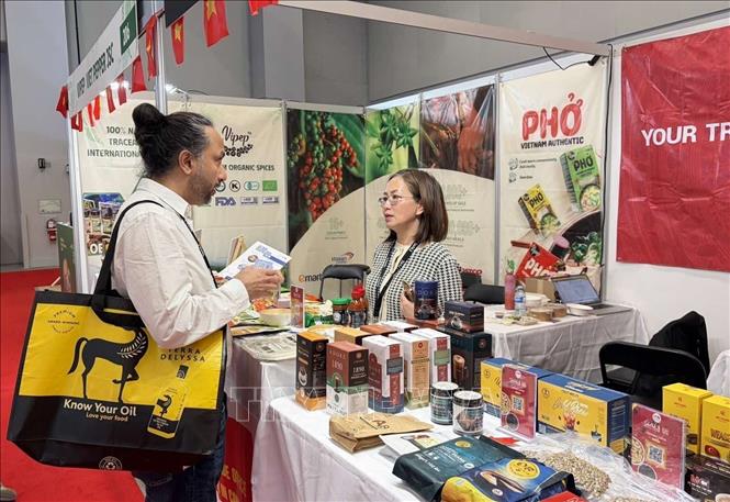 Khách hàng Canada đang trao đổi với đại diện Thương vụ Việt Nam khi thăm quan gian hàng. Ảnh: Hà Linh-PVTTXVN tại Canada