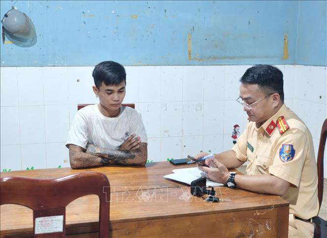 Lực lượng Cảnh sát giao thông lập biên bản xử lý các đối tượng dàn hàng ngang, bốc đầu xe máy trên đường vành đai Trảng cỏ Bù Lạch. Ảnh: TTXVN phát