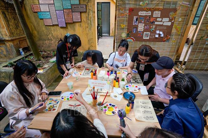 Người dân trải nghiệm thực hiện tác phẩm tranh. Ảnh: Khánh Hoà - TTXVN