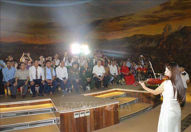 Nghệ sĩ Bùi Cẩm Ly trình diễn violin trên nền bức tranh panorama “Chiến dịch Điện Biên Phủ”. Ảnh: Xuân Tư - TTXVN