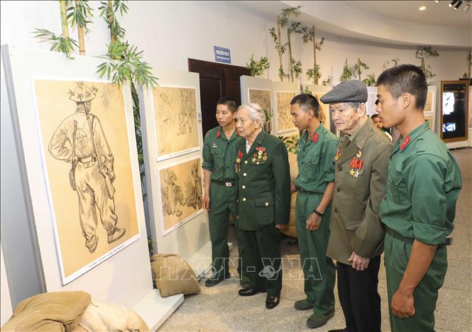 Cựu chiến binh cùng các chiến sĩ trẻ tham quan triển lãm. Ảnh: Xuân Tư - TTXVN