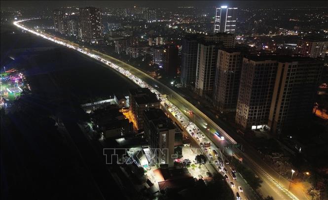 Dòng phương tiện di chuyển đông đúc dài hàng km vào trung tâm và lên Vành đai 3 trên cao từ cao tốc Pháp Vân - Cầu Giẽ trong đêm muộn. Ảnh: Quốc Khánh - TTXVN
