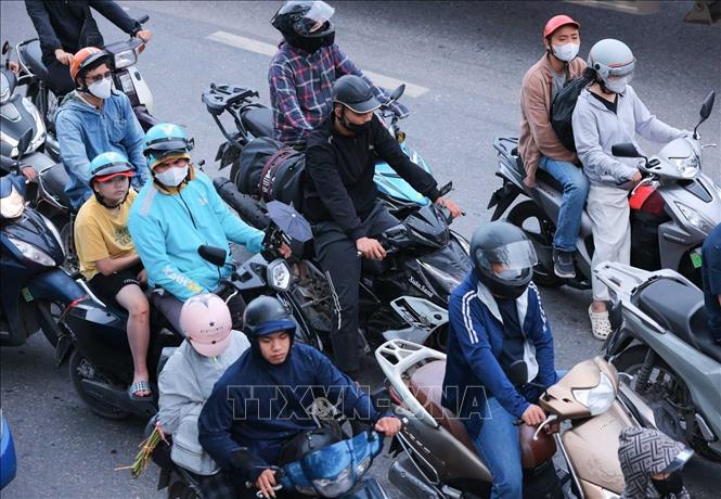 Người dân với hành lý, đồ đạc được chằng buộc cẩn thận hướng từ Quốc lộ 1A đi vào thành phố Hà Nội (ảnh chụp lúc 7h30'). Ảnh: Hoàng Hiếu - TTXVN