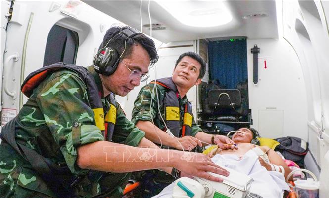 Tổ Cấp cứu đường không, Bệnh viện Quân y 175 xử trí, theo dõi người bệnh trong quá trình vận chuyển về đất liền. Ảnh: TTXVN phát 
