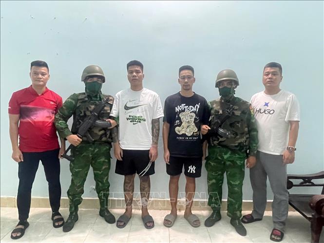 Đối tượng Trần Duyên Thịnh và Nguyễn Tuấn Nam (đứng giữa) cùng trú tại thành phố Hà Nội, bị truy nã về hành vi “Gây rối trật tự công cộng” bị bắt giữ tại Đồn Biên phòng Cửa khẩu quốc tế Mộc Bài. Ảnh: TTXVN phát