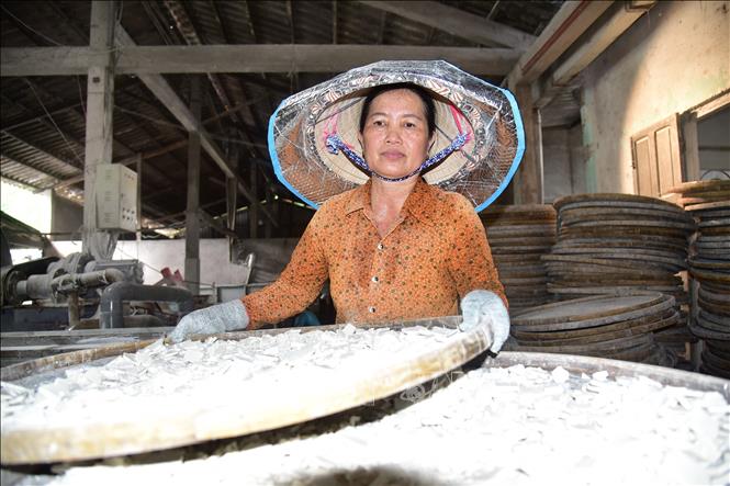 A local arranging rice flour for drying on bamboo plates. VNA Photo: Đức Hạnh
