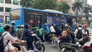 Hơn chục người nâng xe buýt để cứu nữ tài xế xe máy mắc kẹt tại Hà Nội