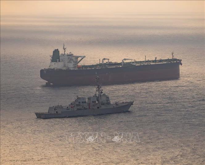 Tàu khu trục USS Rafael Peralta (DDG 115) tiếp cận một tàu hàng đang trong hành trình vào cảng của Iran, trong bối cảnh Mỹ tuyên bố hộ tống tàu qua eo biển Hormuz, ngày 24/4/2026. Ảnh: REUTERS/TTXVN