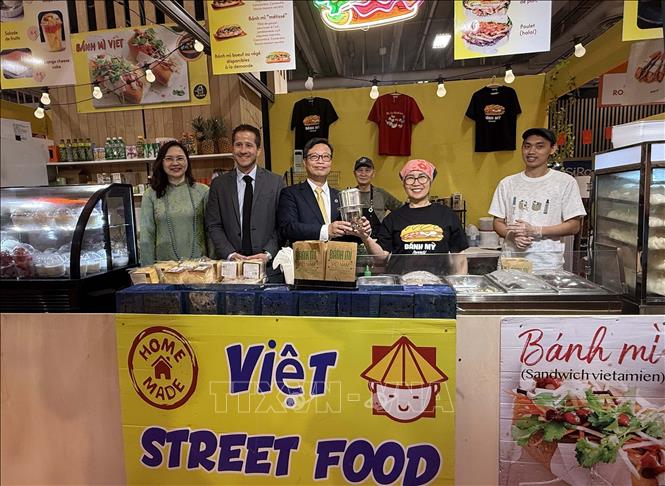 Đại sứ Việt nam Trịnh Đức Hải cùng ông Steven Abajoli, Giám đốc Foire de Paris, và Đại sứ-Trưởng Phái đoàn thường trực Việt Nam bên cạnh UNESCO Nguyễn Thị Vân Anh khám phá gian hàng cà phê của doanh nghiệp Việt Nam tại Hội chợ quốc tế Paris. Ảnh: Hữu Chiến - P/v TTXVN tại Pháp