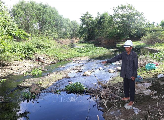 Ông Hà Kiến (84 tuổi) bức xúc vì dòng kênh luôn có màu đen kịt. Ảnh: Đinh Hương - TTXVN