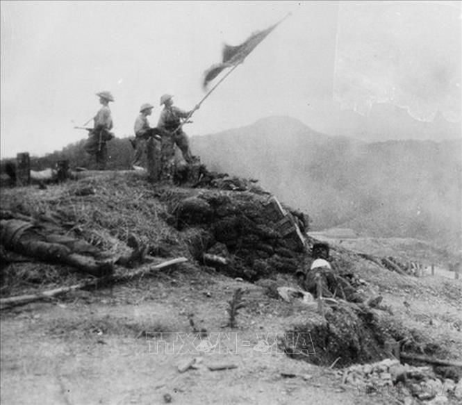 Quang cảnh khu đồi Độc Lập sau khi ta tiêu diệt hoàn toàn vị trí này ngày 14/3/1954. Các chiến sĩ xung kích phất cao lá cờ “Quyết chiến - Quyết thắng” trên nóc hầm chỉ huy của địch. Ảnh: Tư liệu - TTXVN   