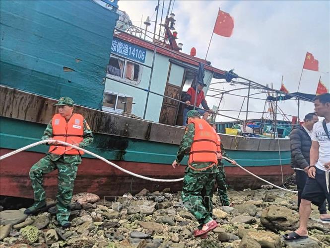 Cán bộ, chiến sĩ Bộ đội Biên phòng Hải Phòng hỗ trợ tàu cá Trung Quốc neo buộc cố định chờ thời tiết thuận lợi sẽ tiến hành lai dắt vào âu cảng. Ảnh: TTXVN phát.
