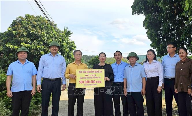 Đoàn công tác đã trao 500 triệu đồng cho mỗi xã bị ảnh hưởng từ Quỹ cứu trợ tỉnh Nghệ An nhằm khắc phục hậu quả do dông lốc, mưa đá. Ảnh: Văn Tý-TTXVN