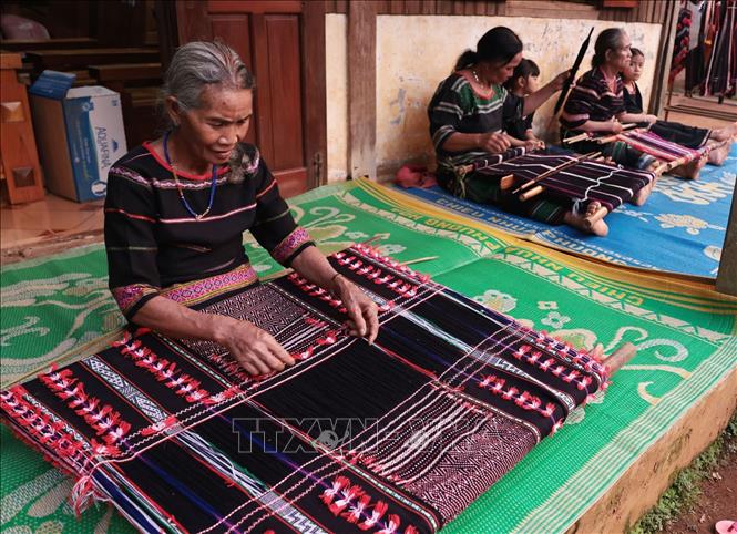 Những người cao tuổi ở thôn Bon R Bút, xã Quang Sơn, tỉnh Lâm Đồng vẫn miệt mài dệt vải. Ảnh: Trần Việt - TTXVN