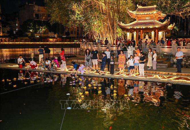 Hoạt động thả đèn hoa đăng thu hút người dân và du khách. Ảnh: Khánh Hoà - TTXVN