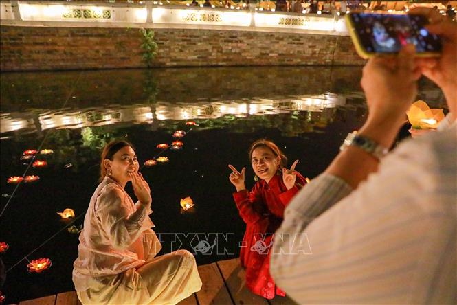 Hoạt động thả đèn hoa đăng thu hút người dân và du khách. Ảnh: Khánh Hoà - TTXVN