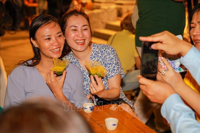 Người dân thích thú trải nghiệm làm đèn hoa đăng. Ảnh: Khánh Hoà - TTXVN